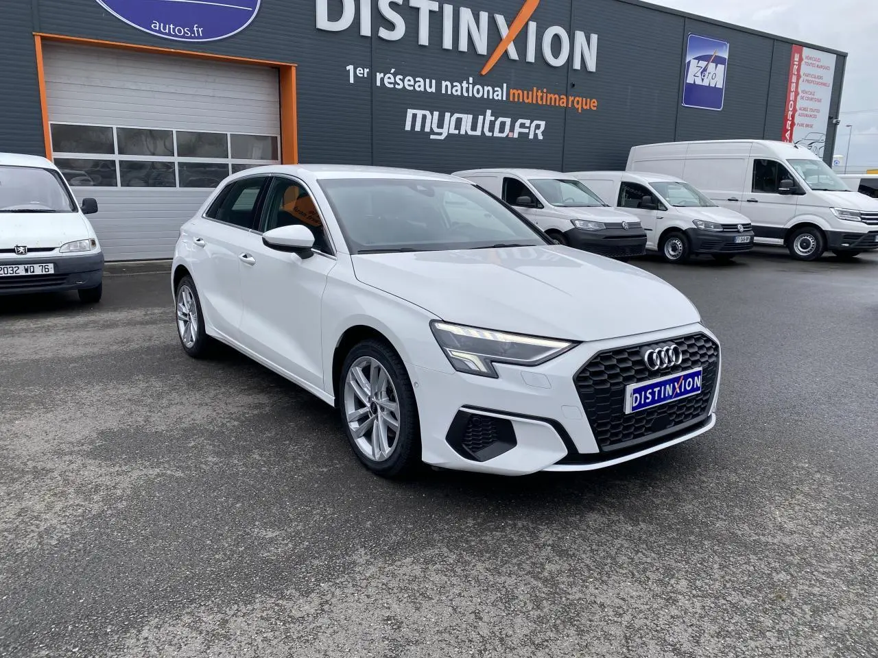 Audi A3 Sportback blanc Ibis vue 3/4 avant droit, avec calandre hexagonale noire et phares LED distinctifs.