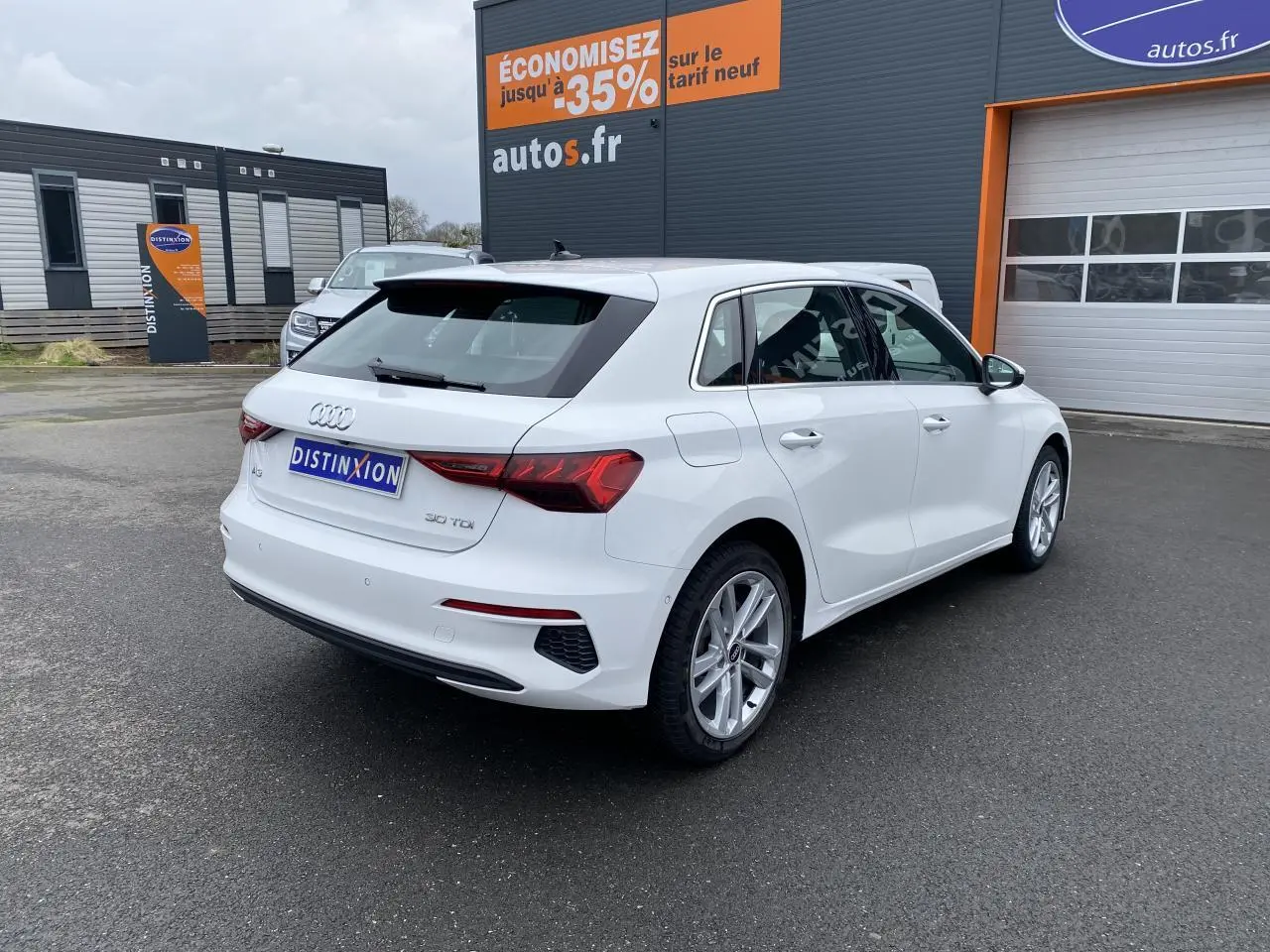 Audi A3 Sportback blanc Ibis vue 3/4 arrière droit, avec feux LED et jantes alliage visibles.
