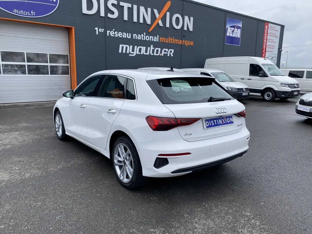 Audi A3 Sportback blanc Ibis vue 3/4 arrière droit, avec feux LED et jantes alliage visibles.