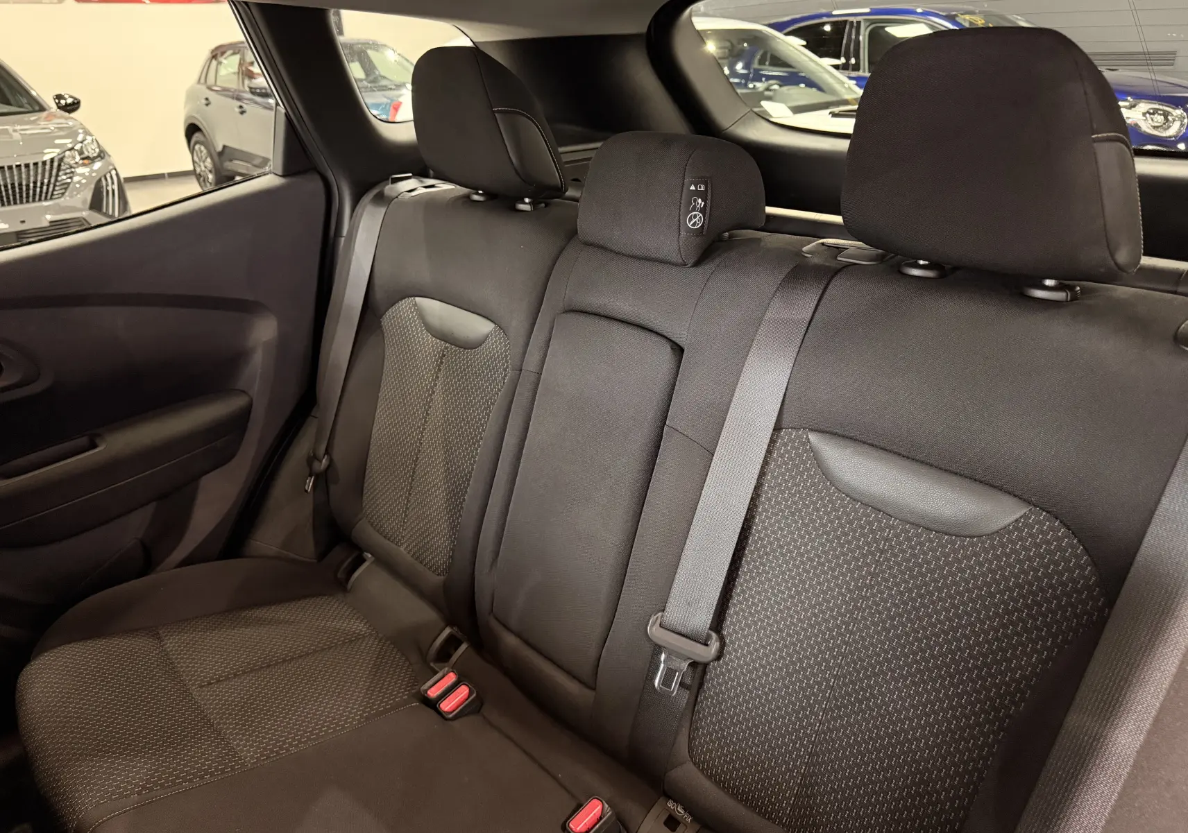 Vue intérieure des sièges arrière en tissu noir du Renault Kadjar 1.5 dCi 115 Business, avec ceintures et appuie-têtes visibles.