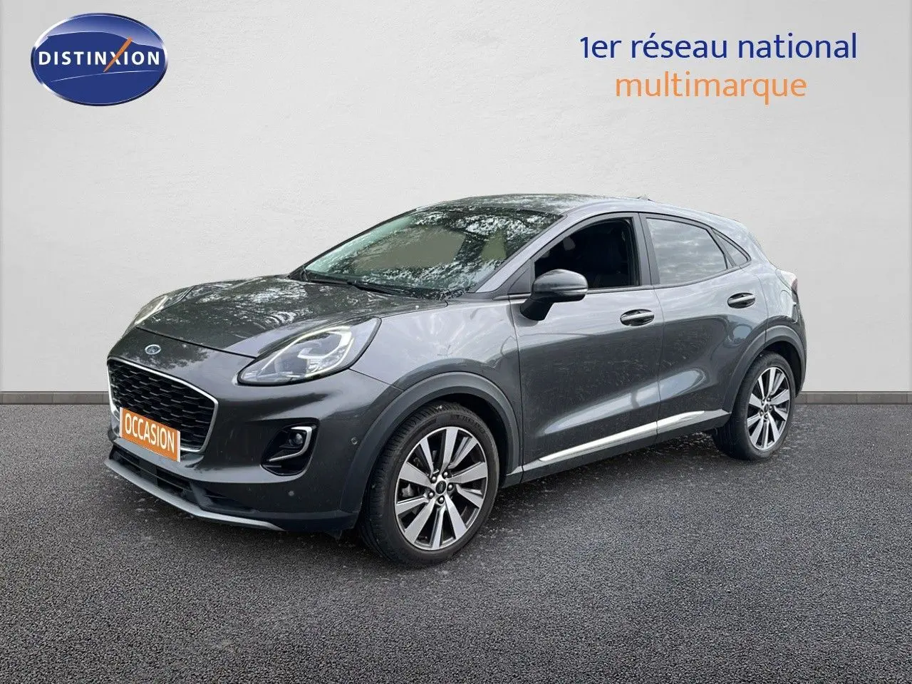 Ford Puma gris en 3/4 avant droit, mettant en valeur ses jantes alliage et son design compact urbain.