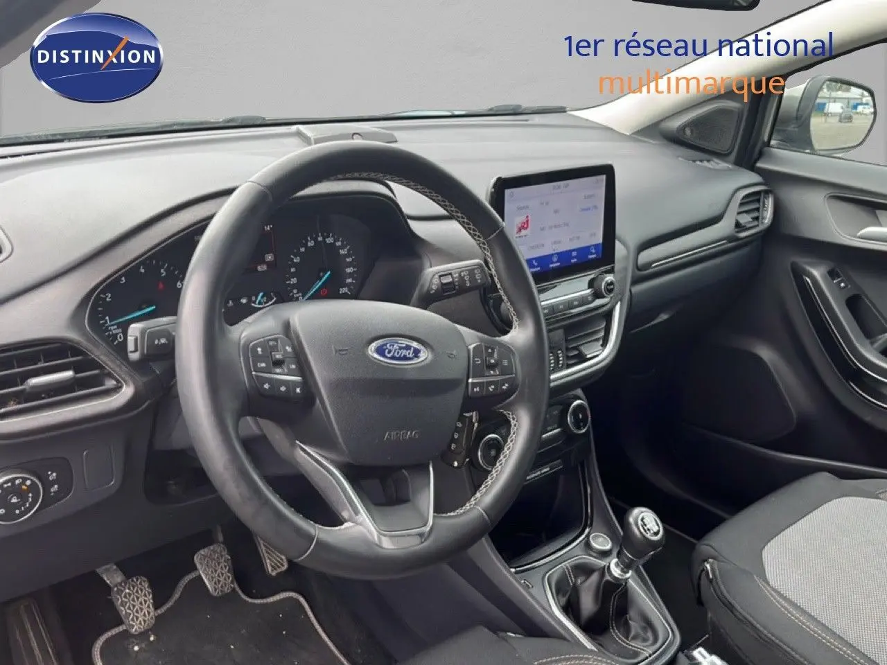 Vue intérieure côté conducteur du Ford Puma gris 2021, montrant le volant multifonction et la console centrale avec écran tactile.