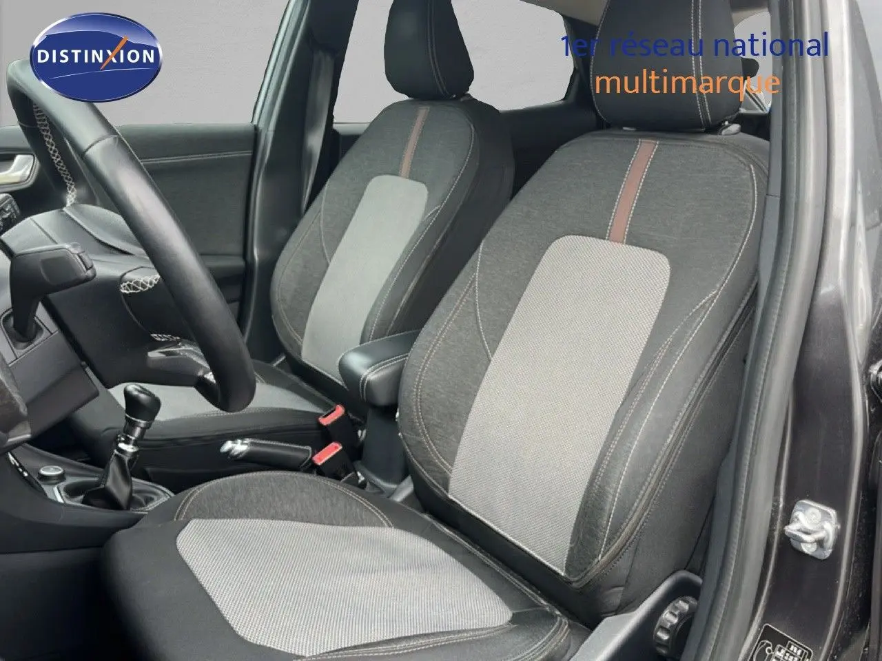 Intérieur du Ford Puma gris 2021, vue côté conducteur montrant les sièges tissu bicolore et la boîte manuelle.