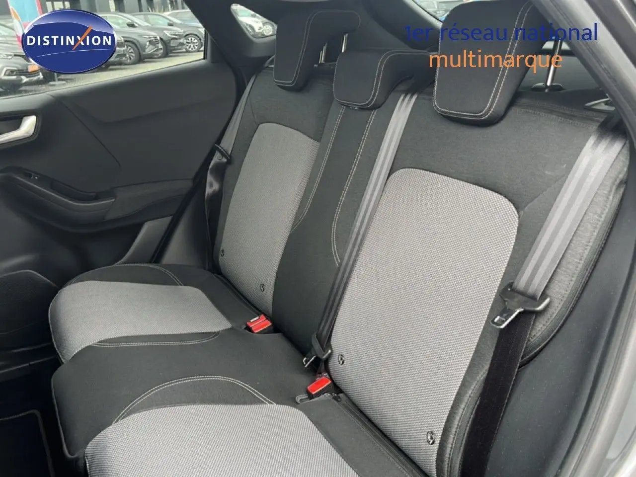 Vue intérieure montrant la banquette arrière en tissu gris clair et foncé du Ford Puma 2021, avec ceintures de sécurité visibles.