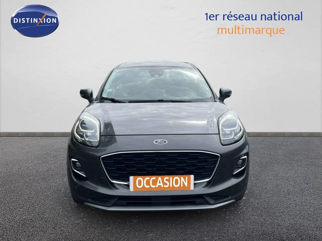 Vue frontale d'un Ford Puma gris 2021 avec calandre noire et phares LED, affichant une plaque "OCCASION".