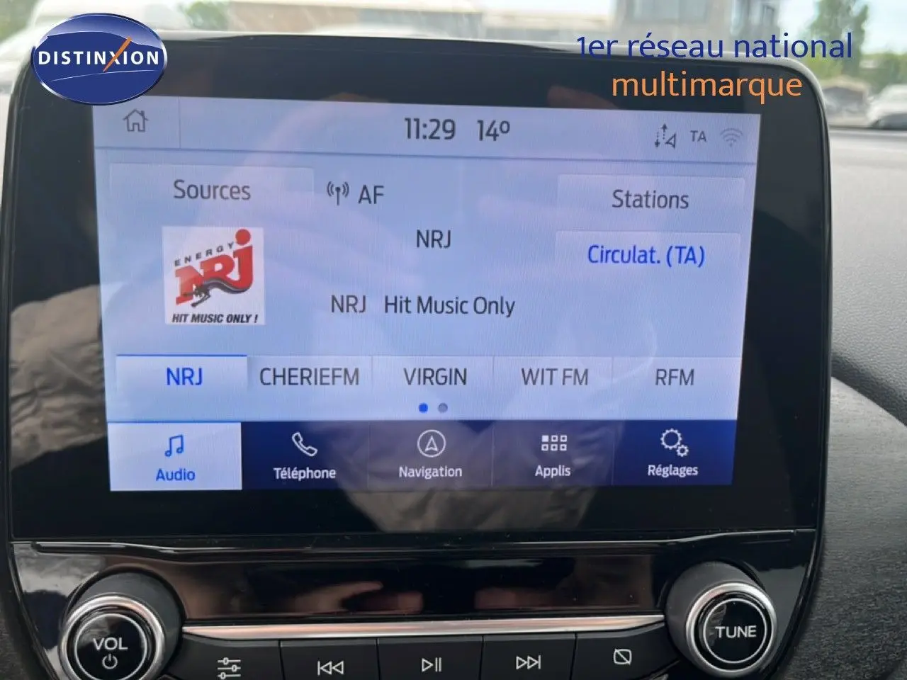 Vue intérieure du tableau de bord du Ford Puma gris 2021, écran tactile multimédia affichant une radio FM.