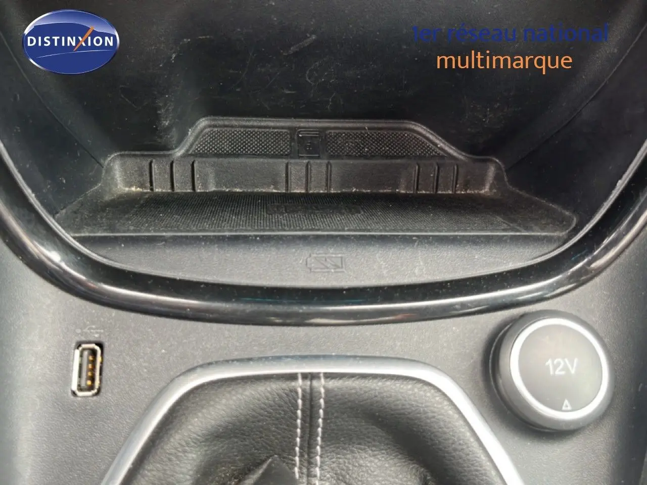 Gros plan sur la console centrale du Ford Puma gris 2021, montrant prise USB, prise 12V et rangement devant levier de vitesses.