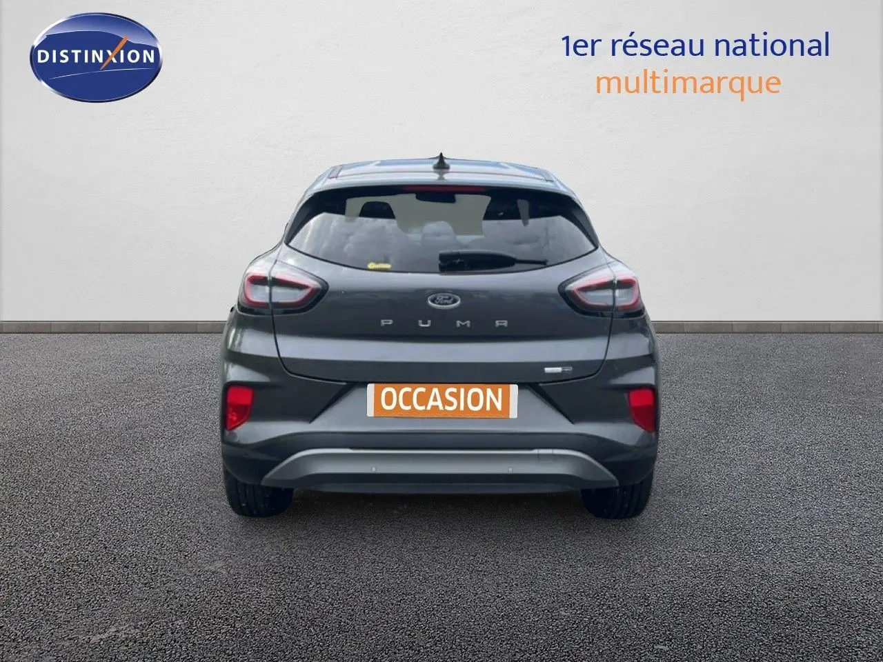 Vue arrière d’un Ford Puma gris 2021 avec feux distinctifs et plaque « OCCASION » sur fond neutre.