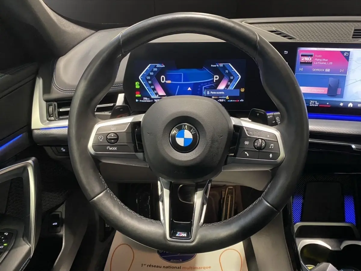 Vue frontale du volant cuir noir et du tableau de bord numérique lumineux du BMW X1 xDrive20d M Sport PRO 2025.