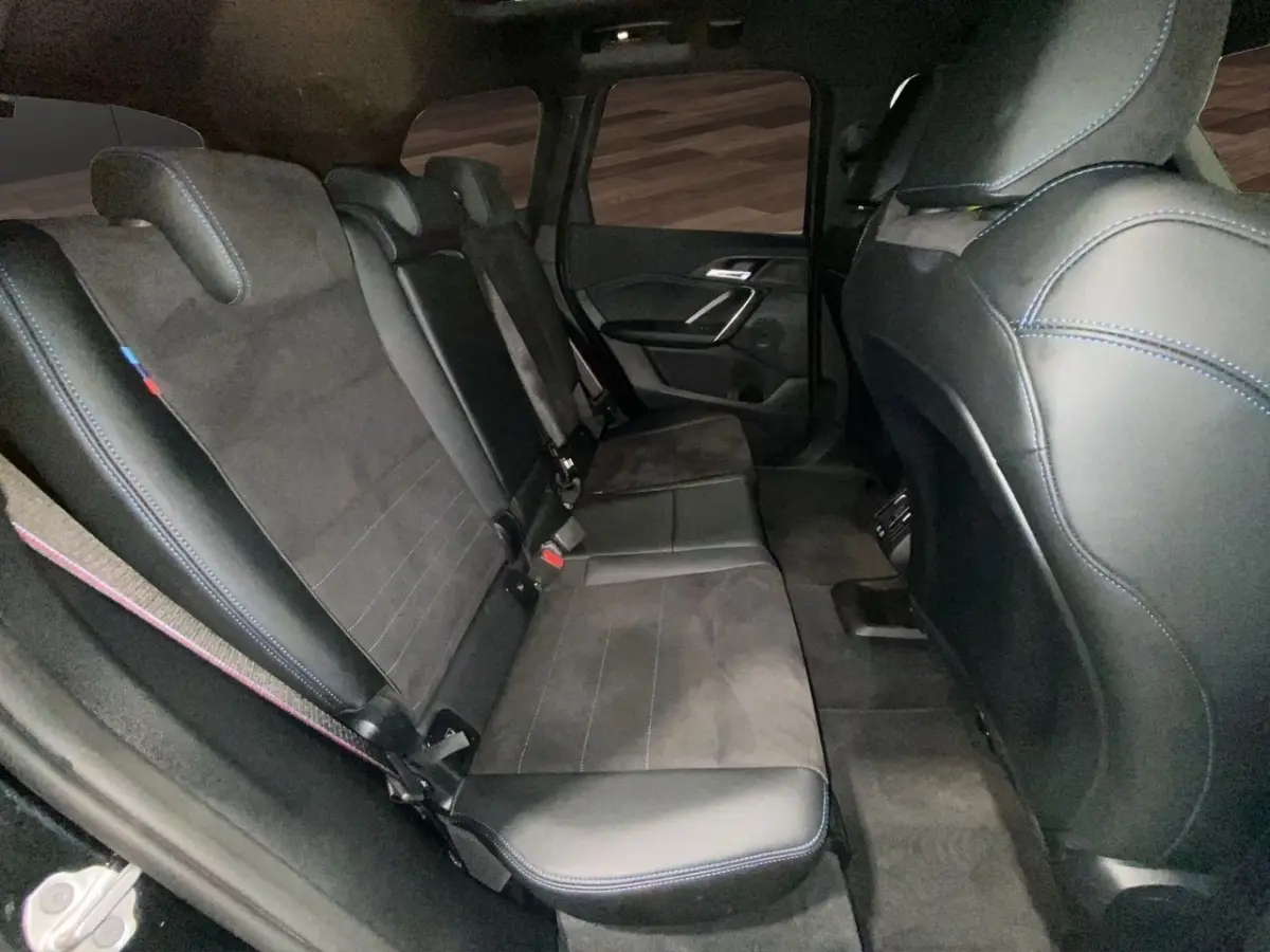 Vue intérieure côté gauche des sièges arrière noirs en cuir et alcantara du BMW X1 xDrive20d M Sport PRO 2025.