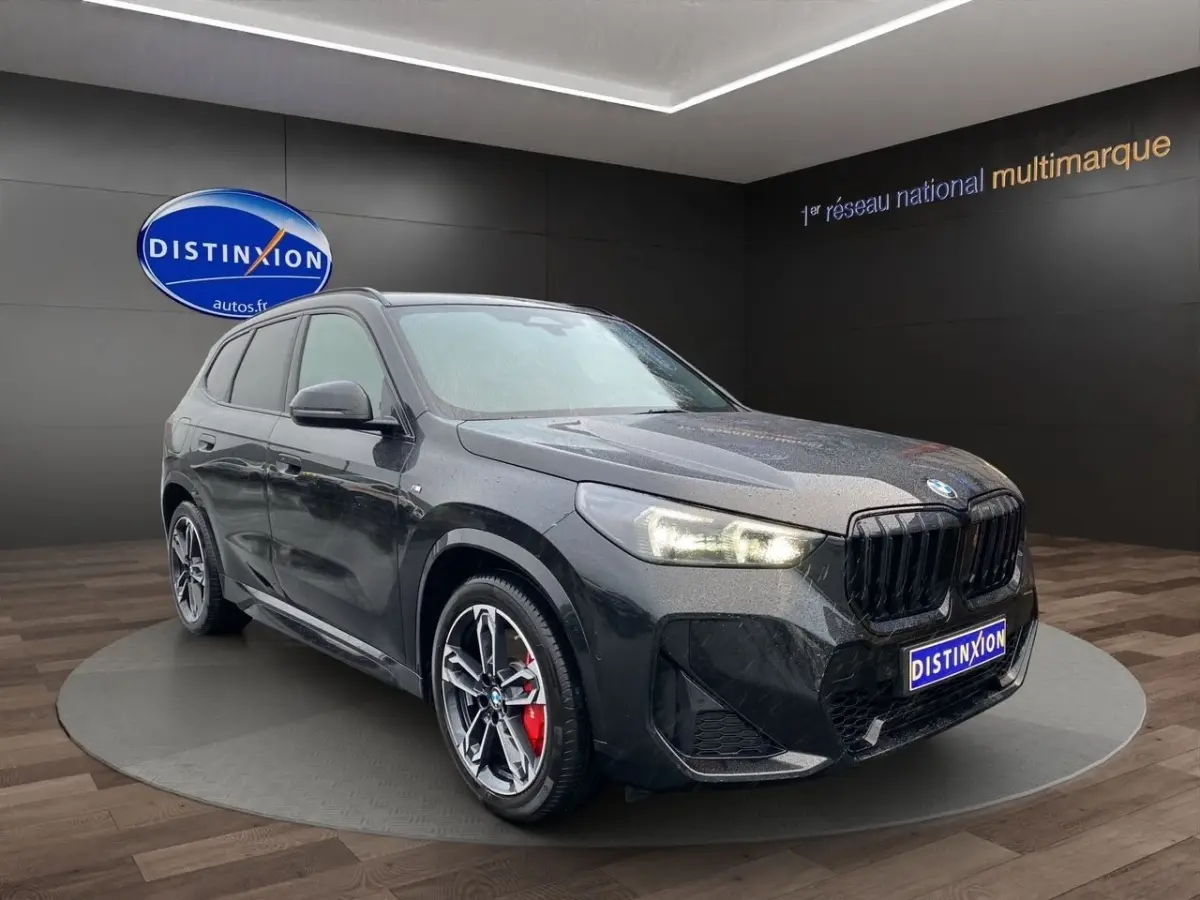 BMW X1 xDrive20d M Sport PRO noir, vue 3/4 avant droit avec jantes sport et calandre noire brillante.
