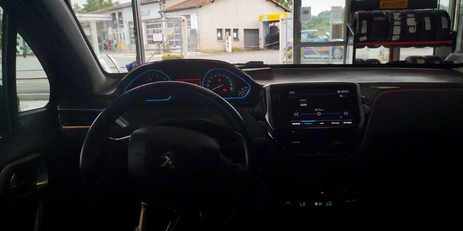 Vue intérieure du tableau de bord et volant noir d'une Citroën Berlingo 2016, avec écran tactile allumé.