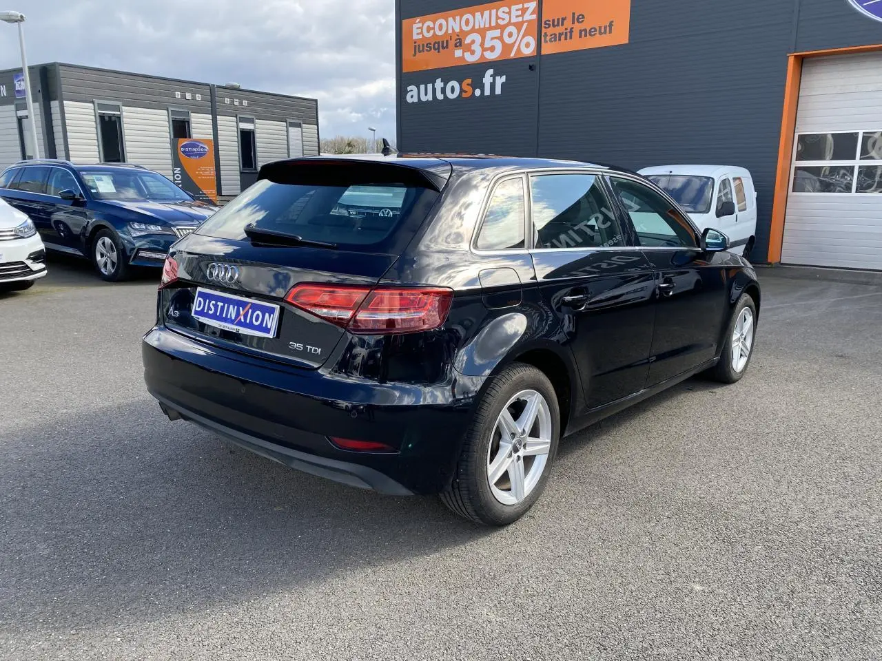 Audi A3 Sportback noir mythic metal vue 3/4 arrière droit, avec jantes alliage et feux arrière LED distinctifs.