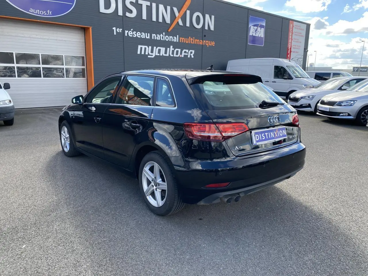 Audi A3 Sportback noir mythic metal vue 3/4 arrière droit, avec feux LED et double sortie d'échappement visible.