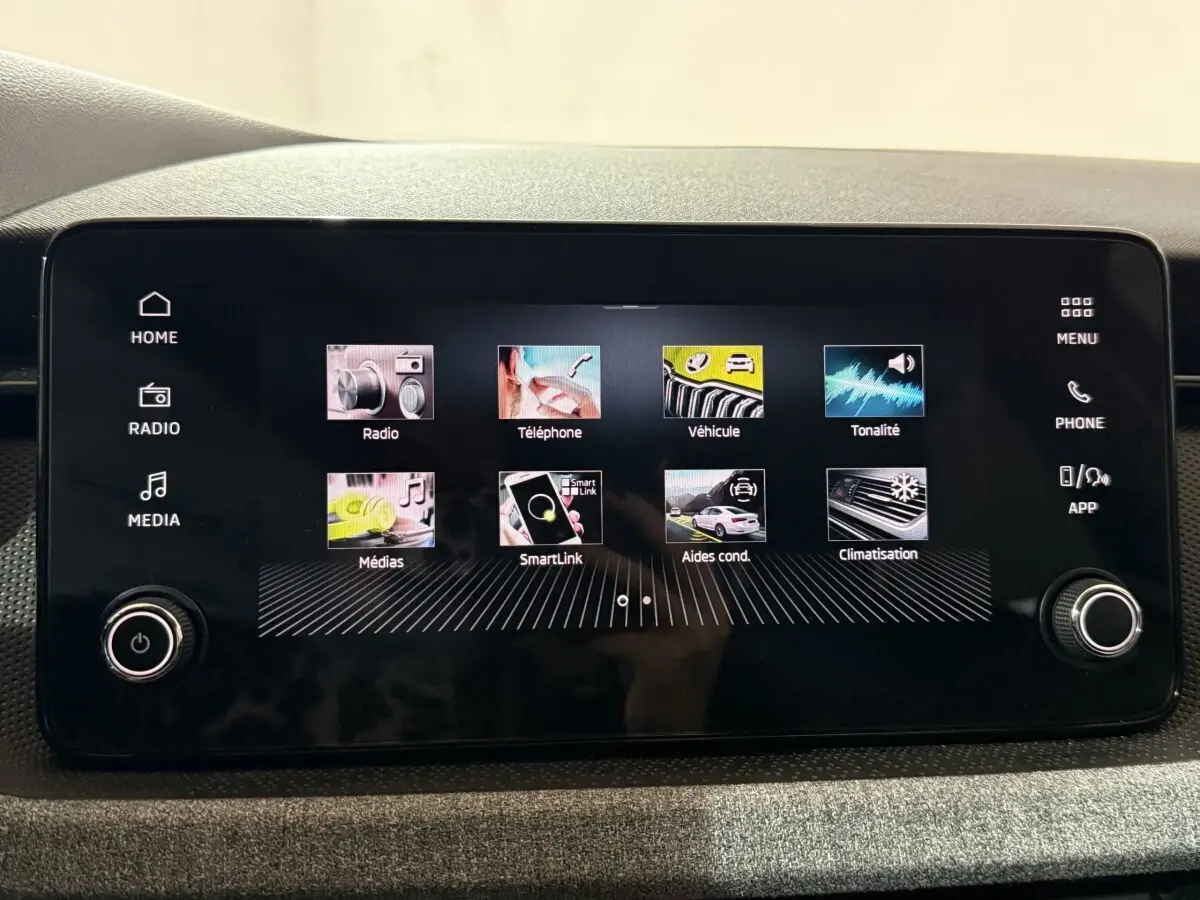 Écran tactile central du tableau de bord du Skoda Kamiq 2024 affichant les menus multimédias et aides à la conduite.