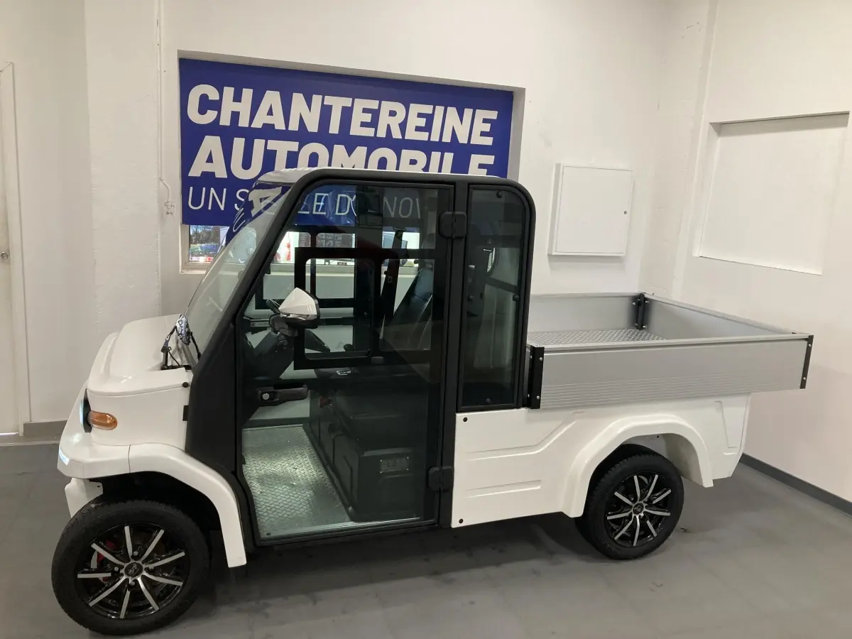 Vue de profil côté gauche du véhicule utilitaire électrique LIBERTY L7E H2 160 blanc avec kit ridelles et jantes alliage 13 pouces.