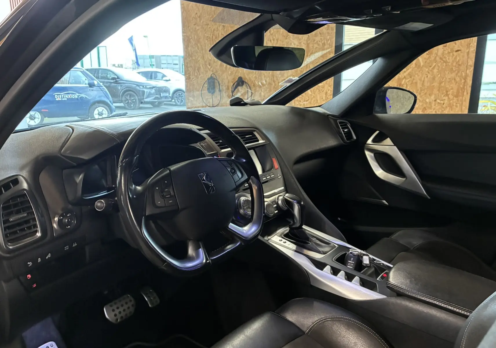 Vue intérieure côté conducteur de la DS5 gris 2018, volant multifonction et console centrale avec boîte auto.