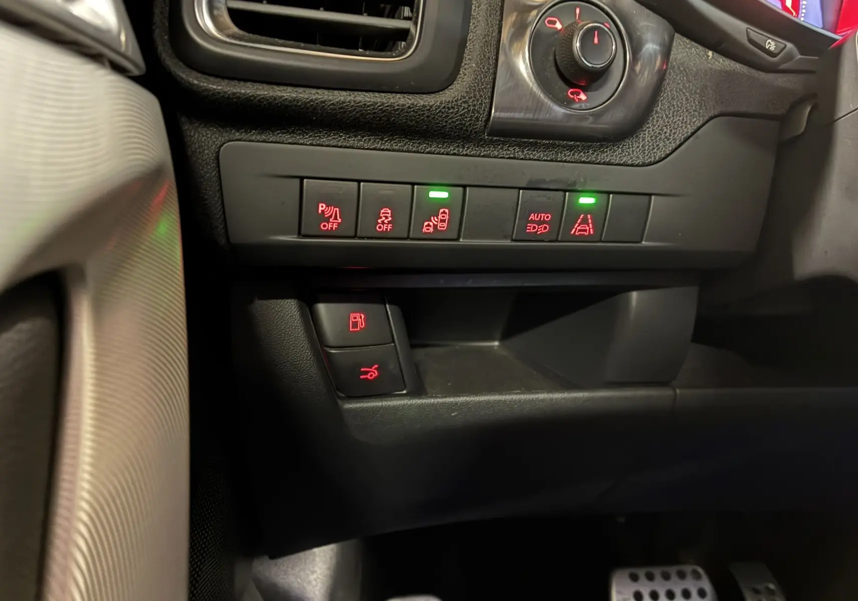 Gros plan sur les commandes de bord à gauche du volant dans l’habitacle noir du DS5 gris diesel 2018.