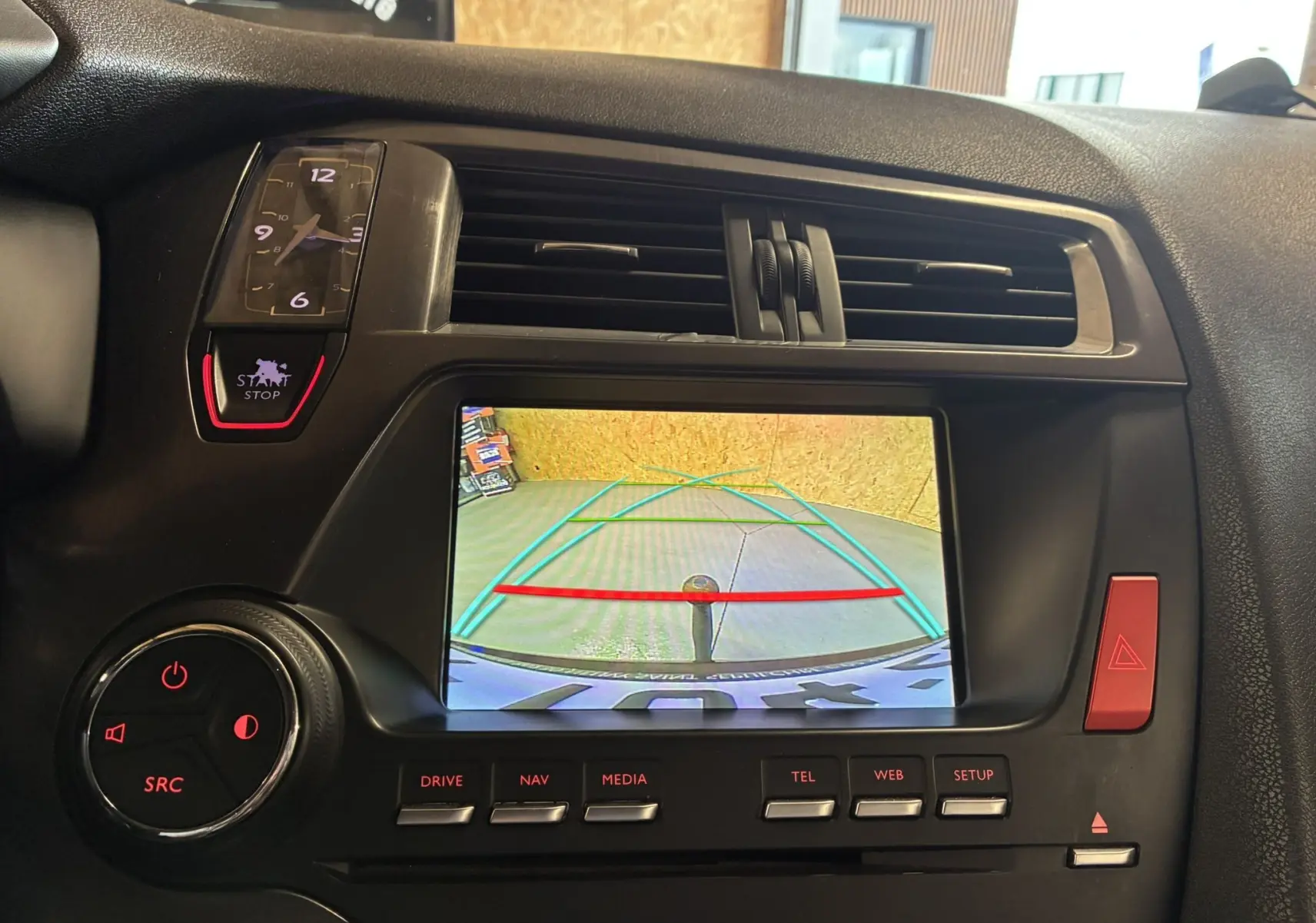 Vue rapprochée de l’écran central de la DS5 gris montrant la caméra de recul avec les lignes de guidage colorées.