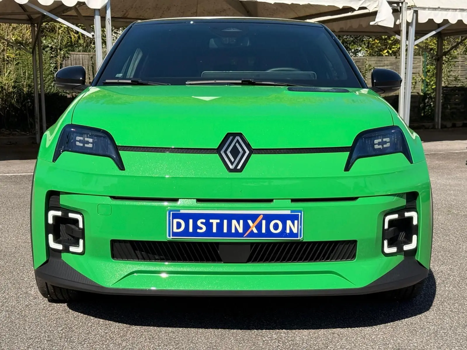 Vue frontale d'une Renault R5 E-TECH électrique 2024 en vert Pop avec toit noir et feux LED distinctifs.