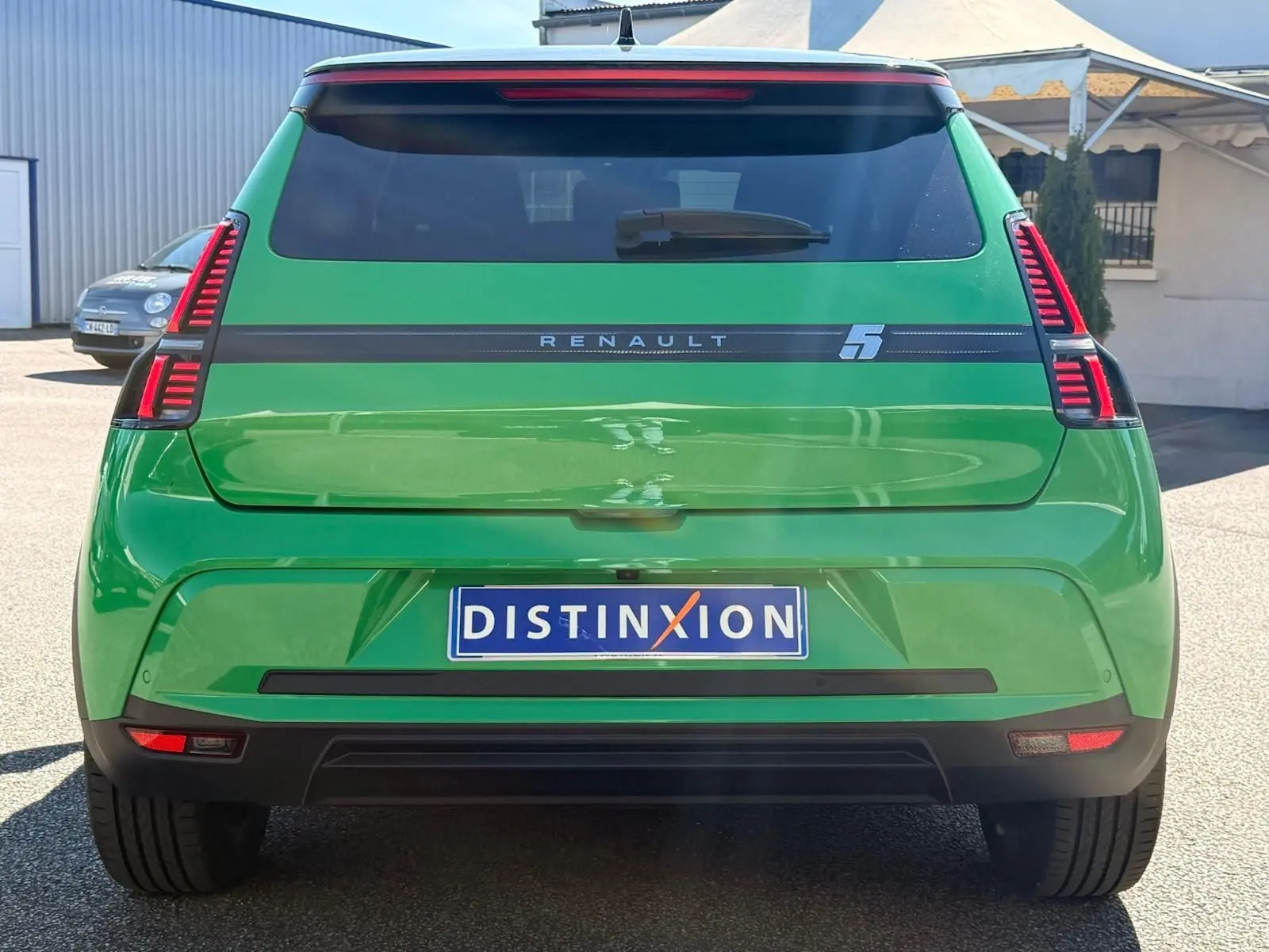 Vue arrière d'une Renault R5 E-TECH électrique 2024 en vert Pop avec toit noir et feux LED verticaux distinctifs.