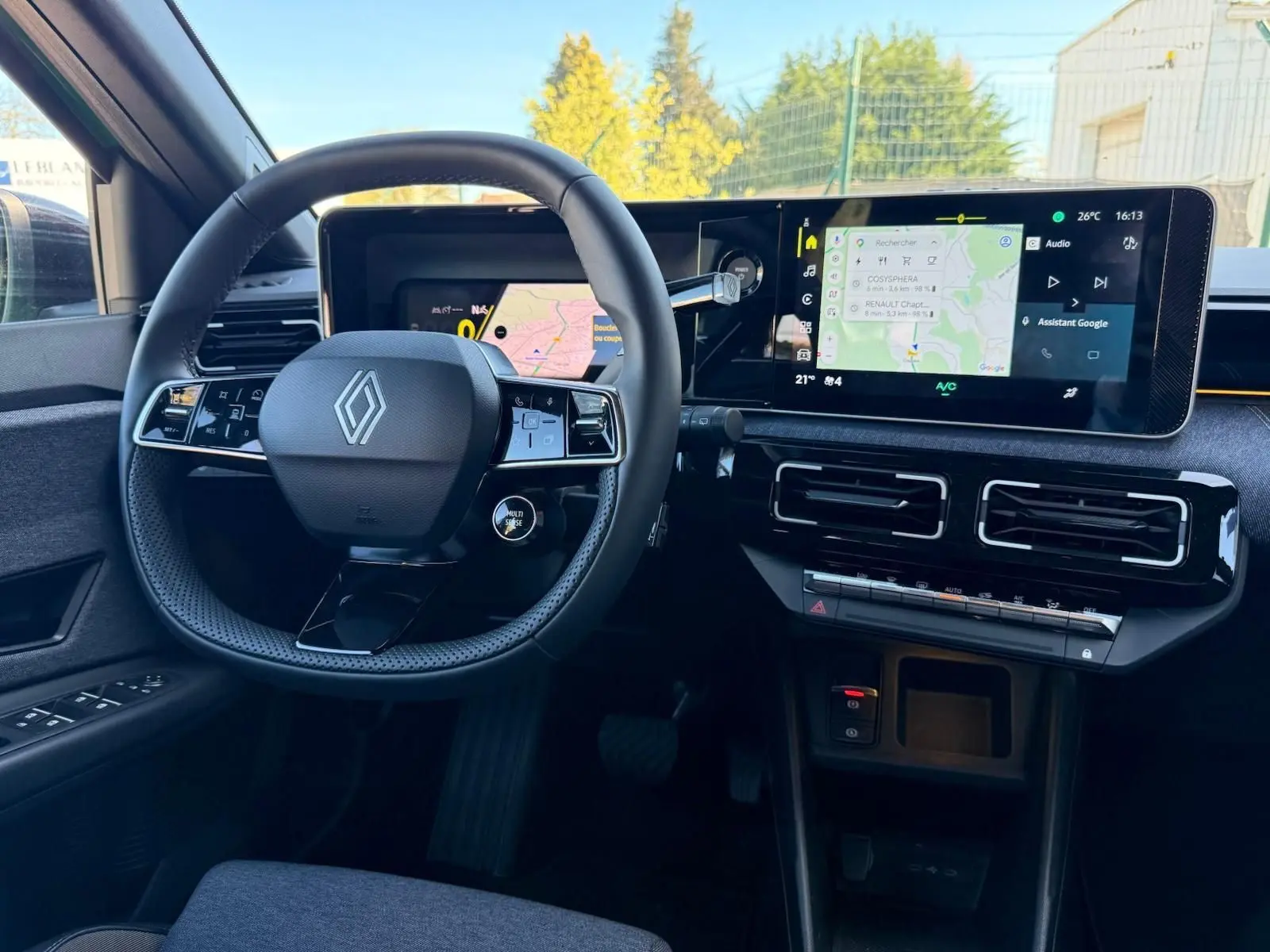 Vue intérieure du poste de conduite de la Renault R5 E-TECH 100% électrique, avec volant compact et écran tactile large.