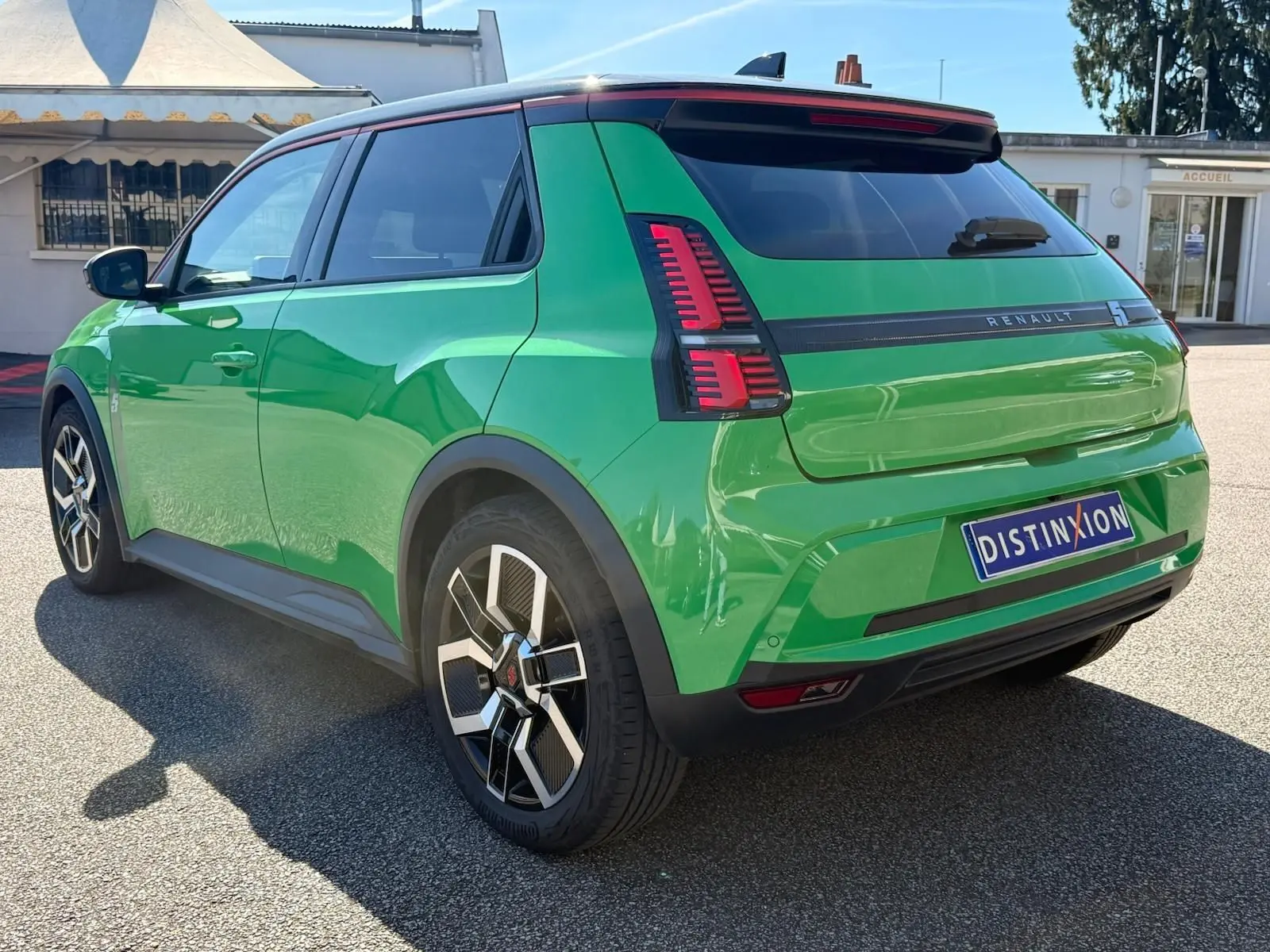 Vue 3/4 arrière gauche d'une Renault R5 E-TECH 100% électrique en vert Pop avec toit noir étoile et jantes biton.
