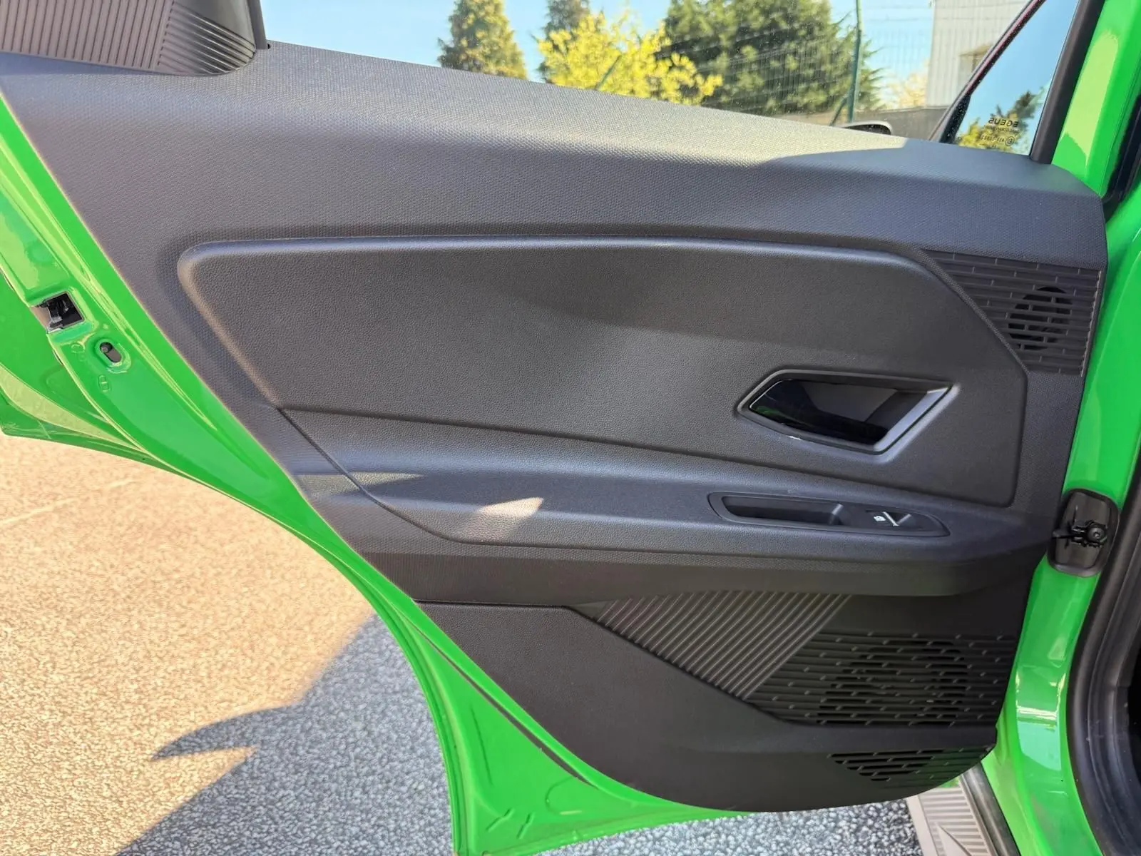 Vue intérieure de la porte arrière gauche verte du Renault R5 E-TECH 100% électrique 2024 avec poignée et commandes fenêtres.