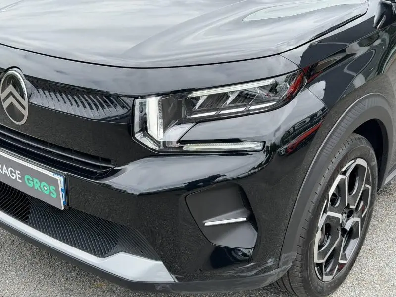 Gros plan sur l'avant droit noir Perla Nera de la Citroën C3 2025 avec phares LED et jante alu distinctive.