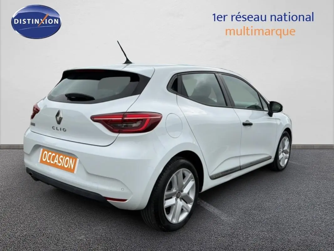 Vue 3/4 arrière droite d'une Renault Clio blanche de 2021, avec feux arrière allumés et jantes argentées.