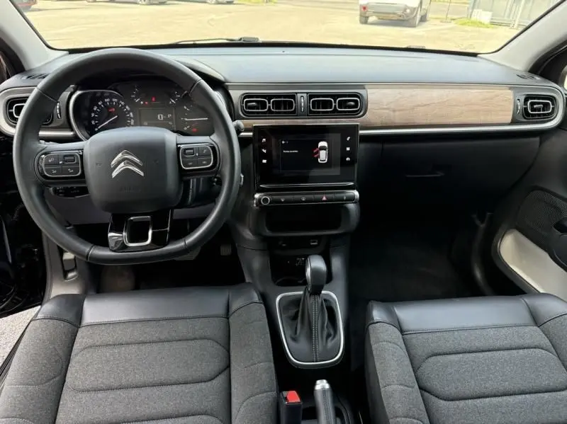 Intérieur avant d'une Citroën C3 2021 essence noir toit blanc, tableau de bord avec écran tactile et volant multifonction.