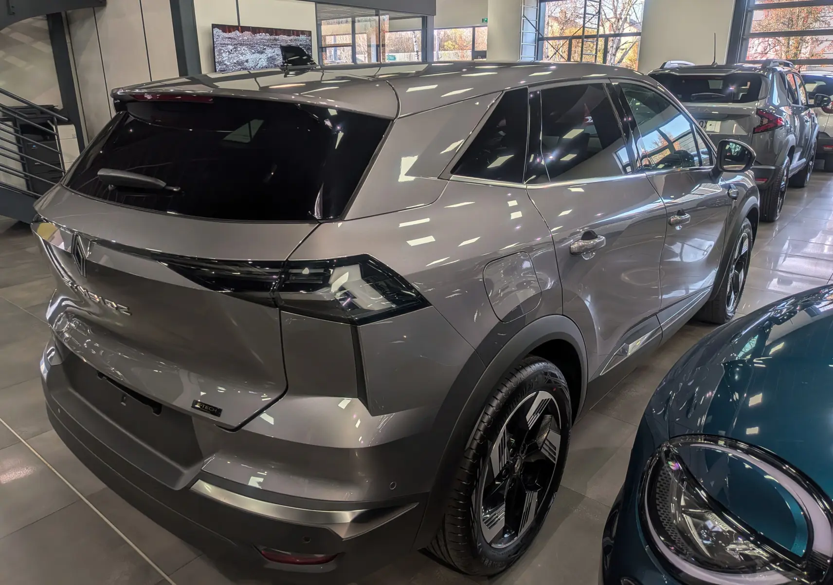 Vue 3/4 arrière droite du Renault SYMBIOZ gris Cassiopé en hybride, soulignant ses feux arrière LED et ses jantes bicolores.