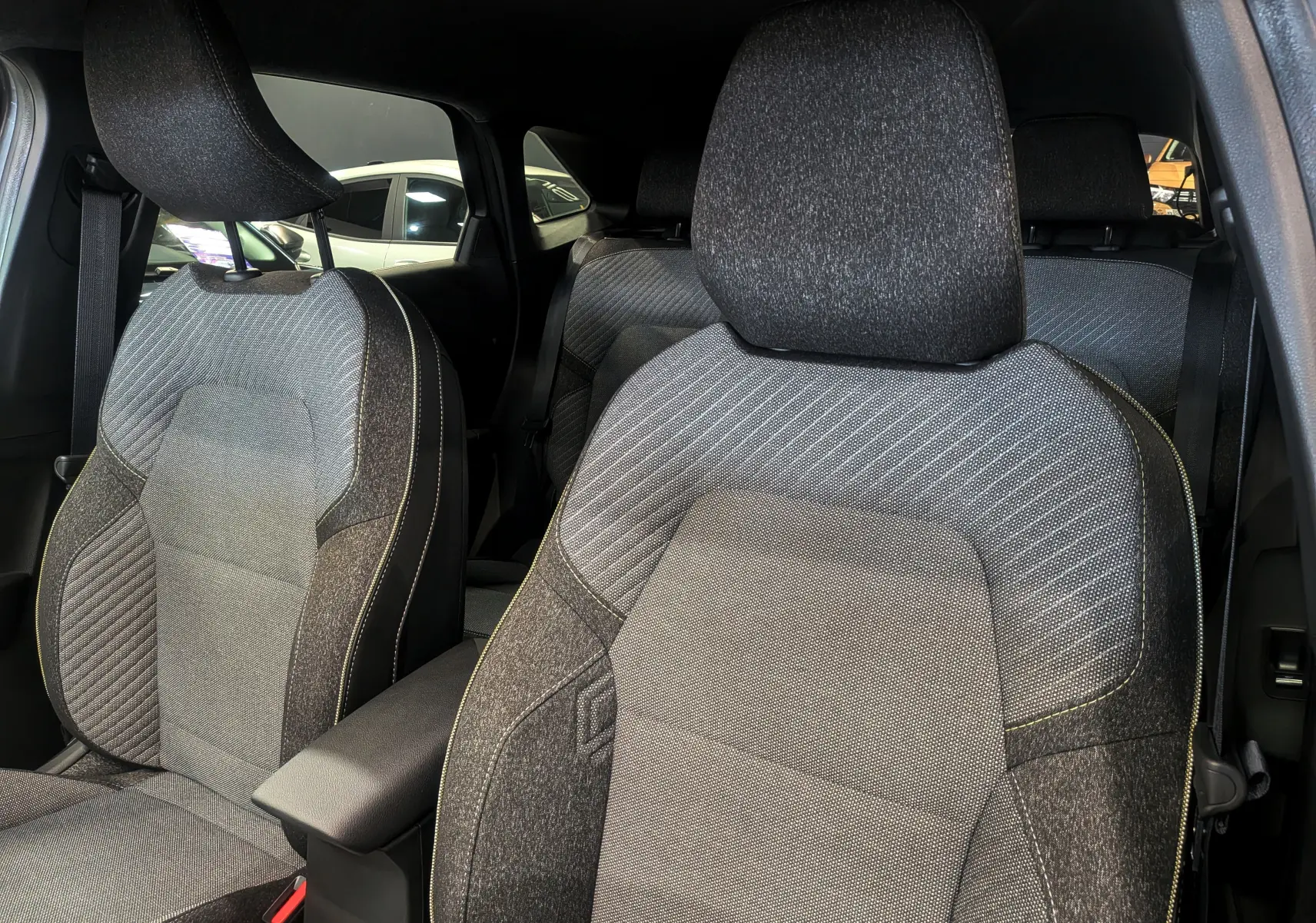 Gros plan sur les sièges avant en tissu gris du Renault SYMBIOZ E-Tech, mettant en valeur leur design et texture.