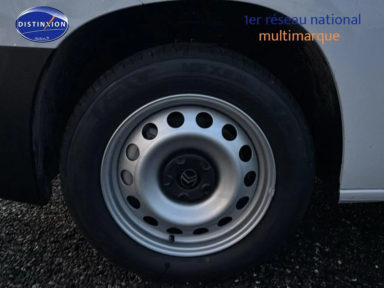 Gros plan sur la roue arrière droite d'un Citroën Berlingo Fourgon blanc, avec jante acier et logo Citroën central.