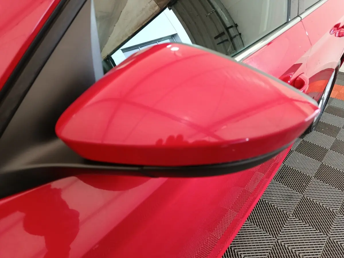 Rétroviseur côté conducteur rouge vif du Skoda Kamiq 2024, vue rapprochée en angle avant gauche.