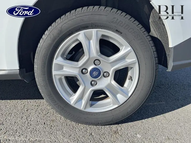 Gros plan sur la roue avant gauche du Ford Transit Courier blanc Glacier, montrant le pneu et l'aile du fourgon.