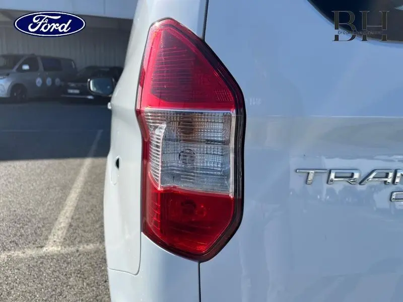 Gros plan sur le feu arrière droit du Ford Transit Courier Fourgon blanc Glacier, avec partie arrière et logo partiel visibles.