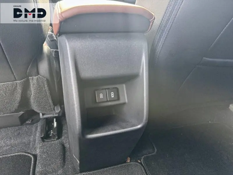 Vue rapprochée de la console arrière noire avec commandes de sièges rabattables du Suzuki Vitara 2026 vert et toit noir.