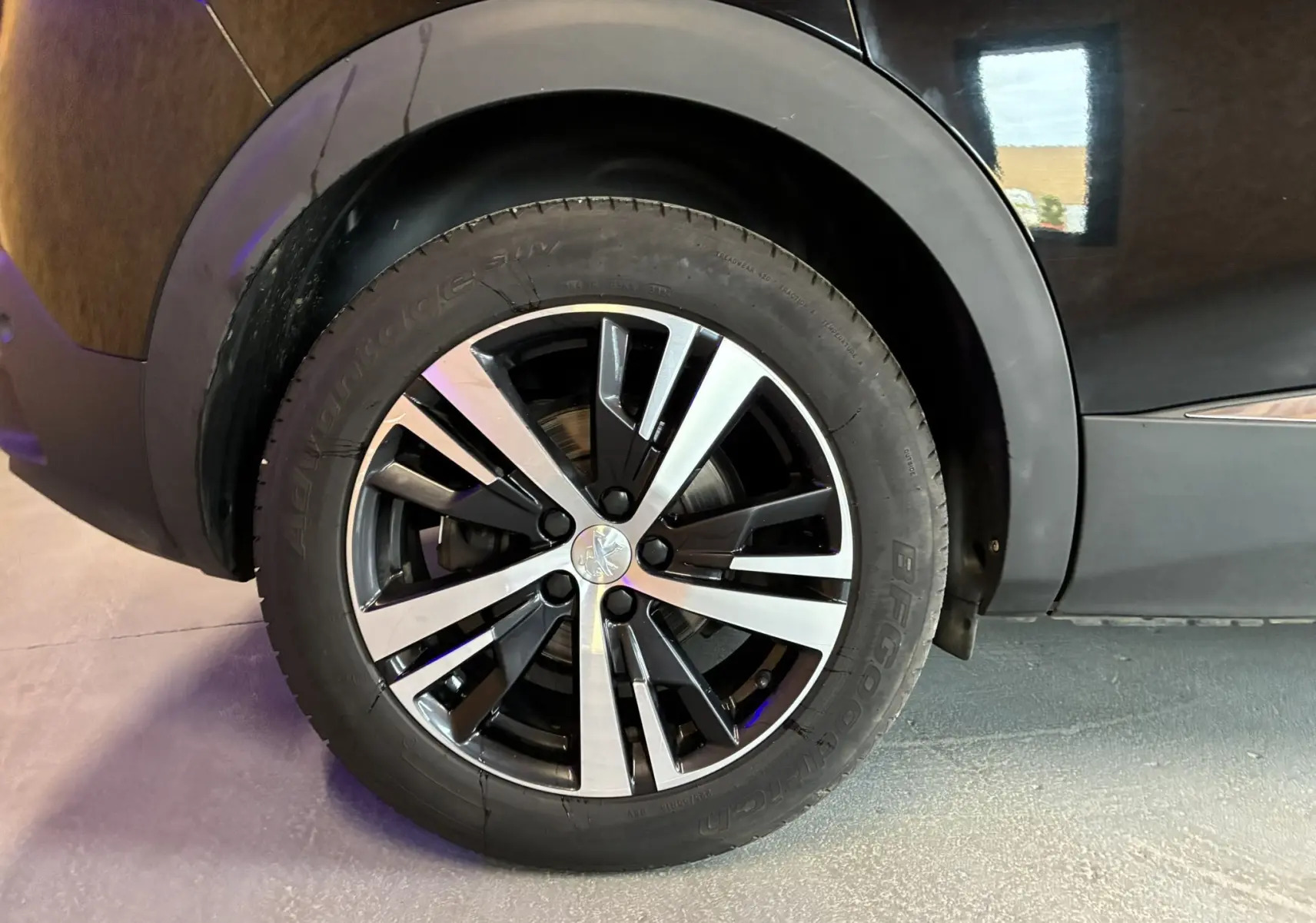 Gros plan sur la roue avant droite noire avec jante alliage bicolore du Peugeot 3008 1.5 BlueHDi 130 Allure Pack 2020.