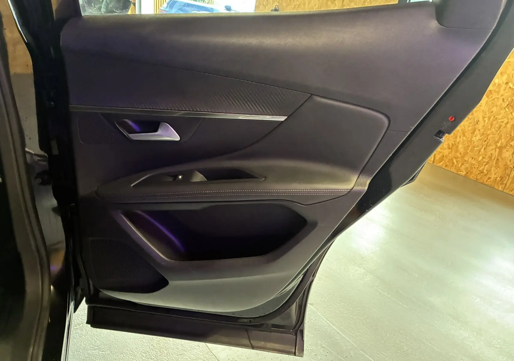 Vue intérieure de la porte arrière gauche noire du Peugeot 3008 1.5 BlueHDi 130 Allure Pack avec garniture tissu et plastique.