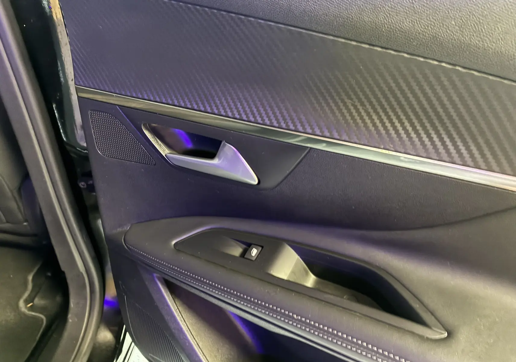 Gros plan sur la porte intérieure côté gauche noire du Peugeot 3008 1.5 BlueHDi 130 Allure Pack avec poignée argentée.