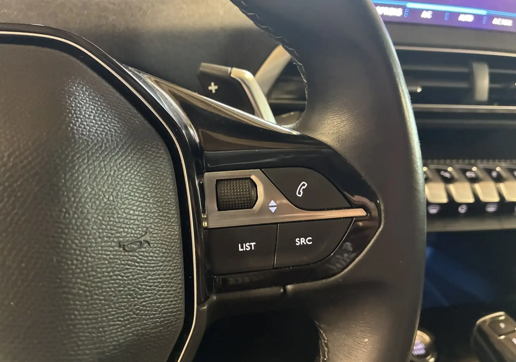 Gros plan sur les commandes au volant côté gauche du Peugeot 3008 noir, version 1.5 BlueHDi 130 Allure Pack de 2020.