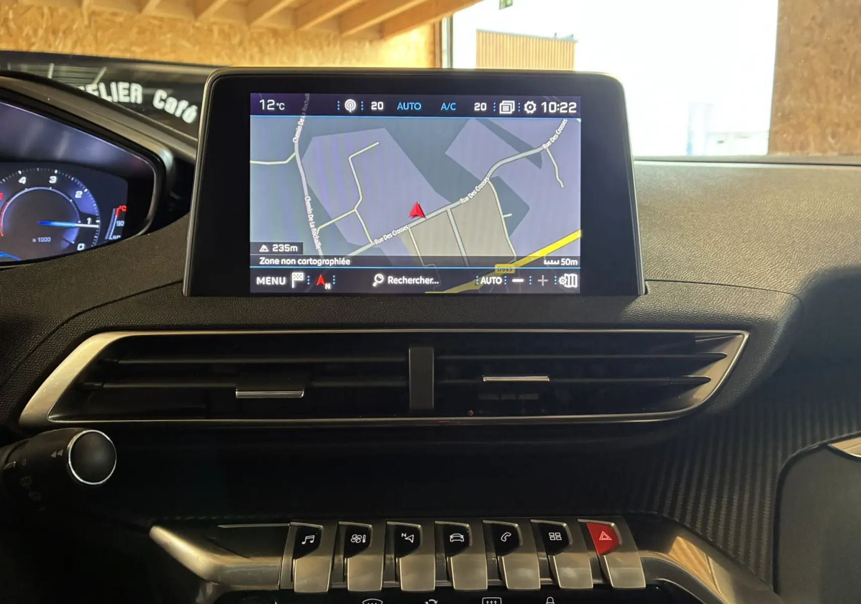 Vue intérieure du tableau de bord du Peugeot 3008 noir, avec écran tactile GPS et rangée de commandes en métal brossé.