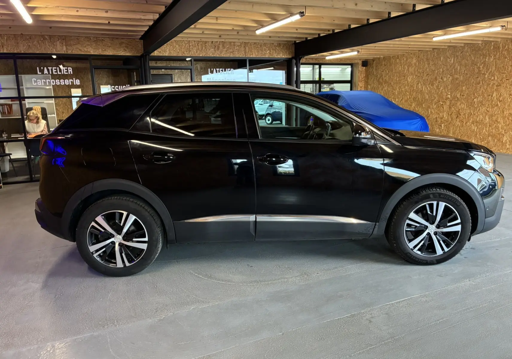 Peugeot 3008 noir vue de profil côté gauche, avec jantes alliage et détails chromés sous les portes.