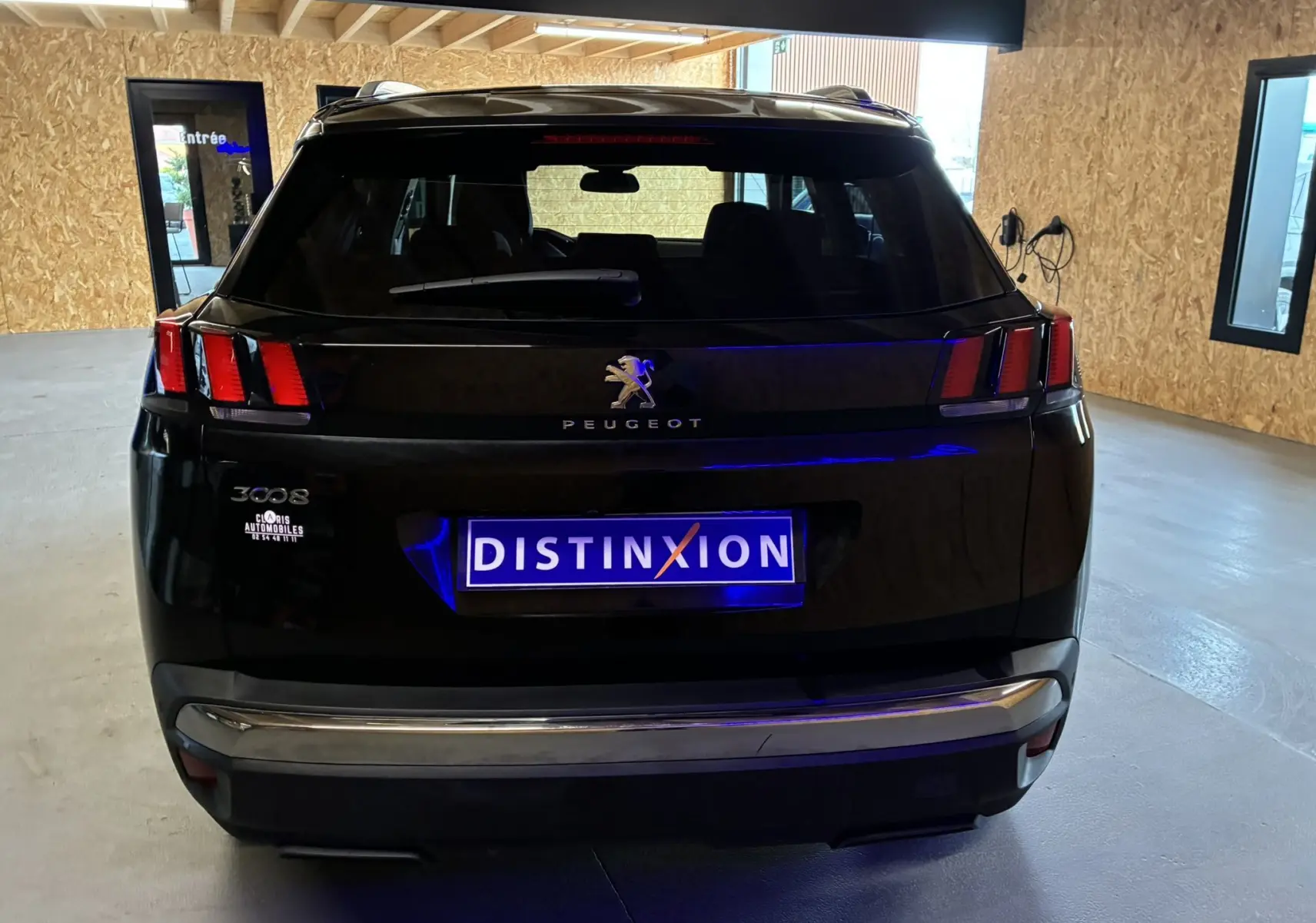 Vue arrière d’un Peugeot 3008 noir 2020 stationné en intérieur avec plaques Distinxion visibles.