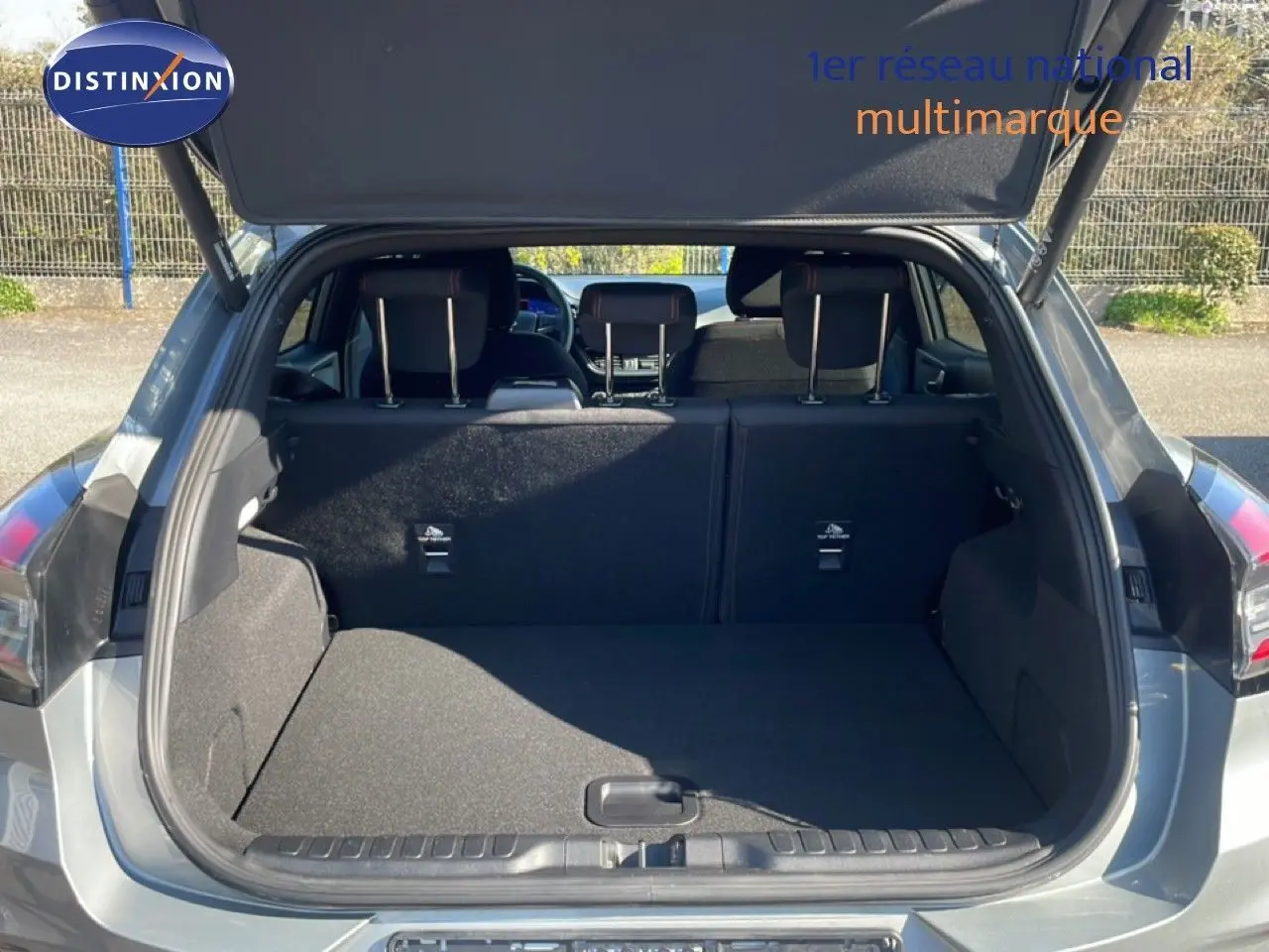 Coffre ouvert vu de l’arrière d’un Ford Puma gris Solar Metal, montrant l’espace de chargement et les sièges arrière.