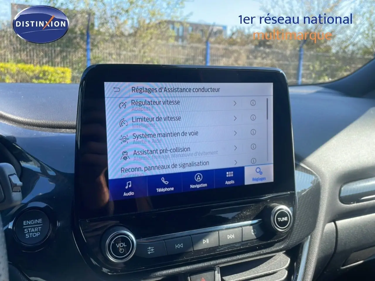 Vue intérieure centrée sur l'écran tactile du tableau de bord d'une Ford Puma 2023, avec commandes d'assistance visibles.