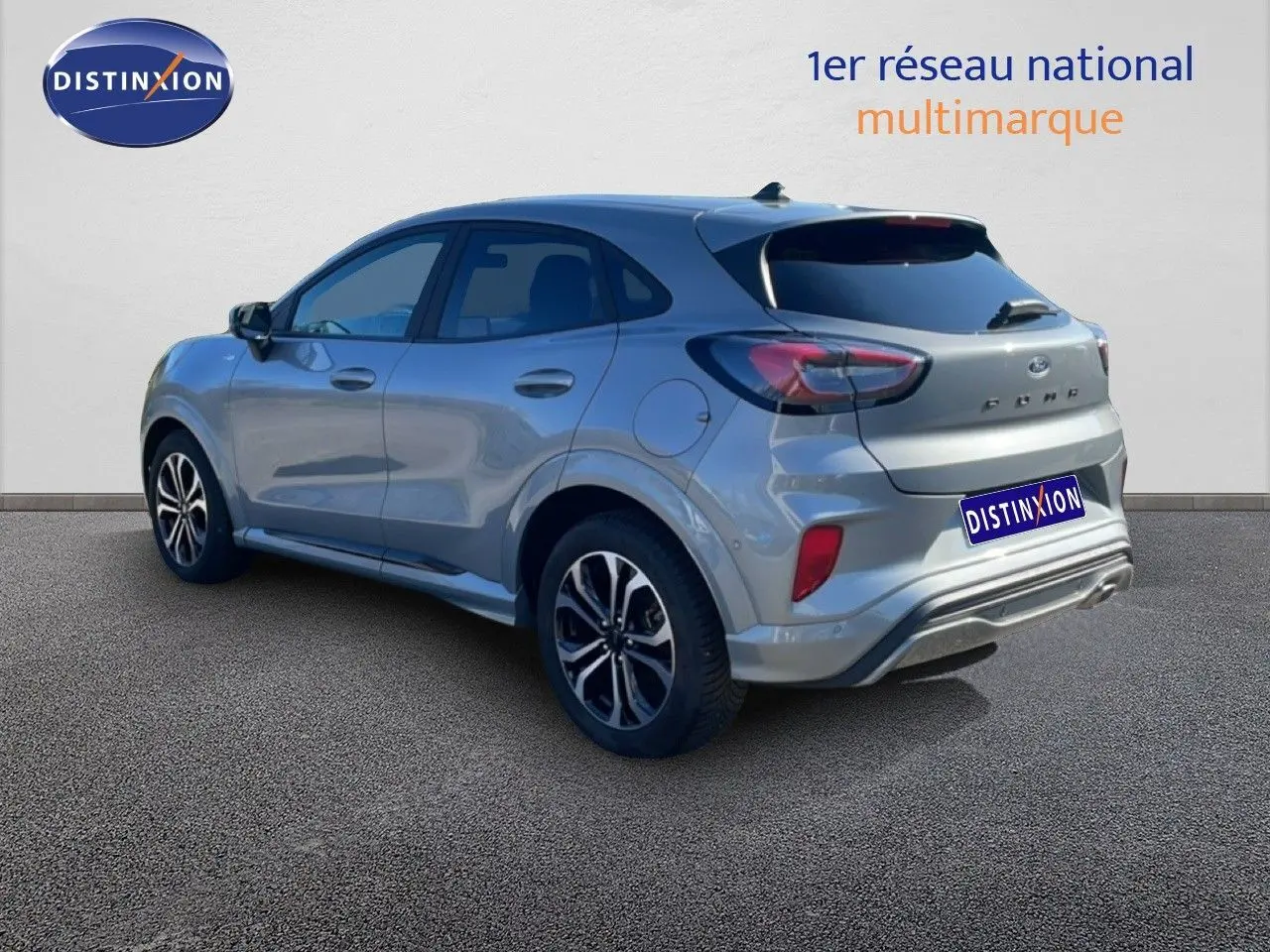 Vue 3/4 arrière droite d'un Ford Puma gris Solar Metal 2023 avec jantes alliage et feux LED distinctifs.