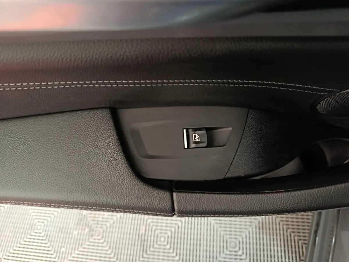 Détail de la commande de verrouillage de porte sur la garniture intérieure côté gauche d’un BMW X3 gris foncé xDrive30e 2020.