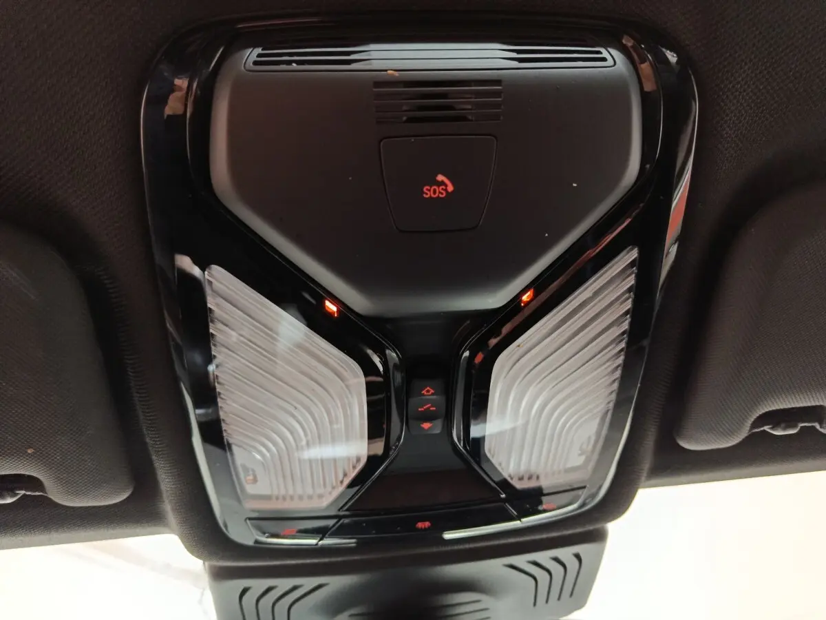 Vue intérieure en plongée du plafonnier noir avec bouton SOS rouge du BMW X3 xDrive30e gris foncé 2020.